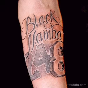 Фото тату на предплечье, посвященное Коби Брайанту: надпись "Black Mamba" и номер "24" в стилизованном дизайне. Черно-белая графика.