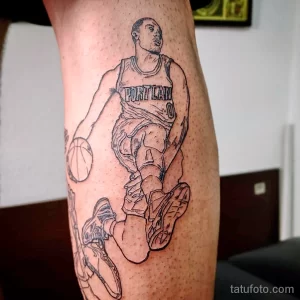 Фото контурной татуировки на ноге с изображением баскетболиста в форме Portland Trail Blazers. Лаконичный черно-белый рисунок.