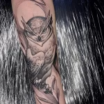 Фото татуировки совы в стиле blackwork на руке. Изображение выполнено полностью в черном цвете с использованием точечной техники.