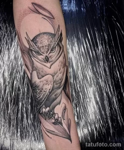 Фото татуировки совы в стиле blackwork на руке. Изображение выполнено полностью в черном цвете с использованием точечной техники.