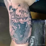 Фото тату на ноге: танк, пальмы, надпись 'Born to Kill', реалистичный стиль, яркие цвета, дерзкий дизайн.