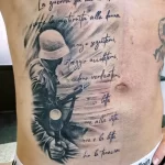 Фото тату на животе с изображением солдата и надписью на итальянском языке. Детализированный рисунок в стиле реализм, выполненный опытным мастером тату.