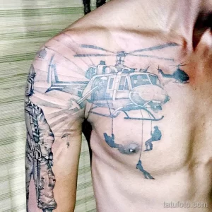 Фото тату: масштабная татуировка на груди и плече с изображением вертолета, спускающего десантников, выполненная в реалистичном стиле.
