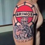 Фото тату на плече: реалистичное изображение бойца спецподразделения BRIMOB в полной экипировке, с надписью 'KILL OR BE KILLED' и символикой подразделения.