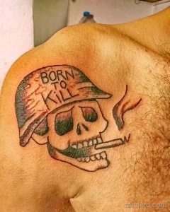 Фото тату на груди: череп в военной каске с надписью "Born to Kill". Черно-белая графика, агрессивный стиль.