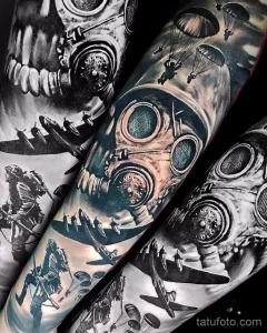 Фото тату: масштабная татуировка на руке с изображением газовой маски, самолетов и парашютистов, выполненная в черно-белом стиле.