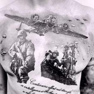 Черно-белое фото тату на груди с изображением военной сцены, включающей самолет, солдат и взрывы. Детализированный рисунок татуировки.