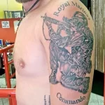 Фото тату на плече: морской пехотинец с оружием и надписью "Royal Marines Commando". Черно-серый рисунок татуировки в реалистичном стиле.