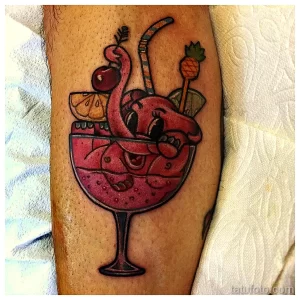 Фото тату яркого коктейля с осьминогом, выполненного в мультяшном стиле на предплечье. Идеальный эскиз тату для любителей морской тематики и напитков.