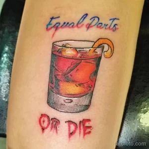 Фото тату коктейля в стакане с долькой апельсина и надписями "Equal Parts" и "OR DIE". Стиль реализм, яркие цвета.