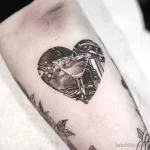 Фото татуировки в стиле blackwork с изображением бокала в форме сердца на руке.