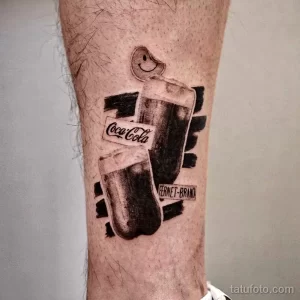 Фотография черно-белой татуировки с изображением бутылки Coca-Cola и стакана Fernet-Branca, выполненной в стиле треш-полька с брызгами краски и штрихами.