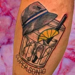 Фото тату: красочный рисунок коктейля Super Sonic в стакане с крышкой и трубочкой, с надписью 'Super Sonic'.