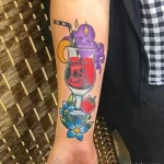Фото тату в стиле олд скул: череп в коктейльном бокале с клубникой и долькой апельсина на руке.