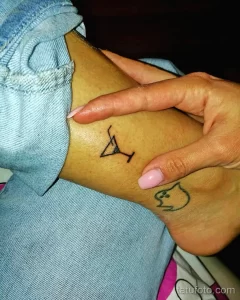 Фото тату на запястье: минималистичный рисунок кошки и самолета. Простой и элегантный дизайн татуировки.