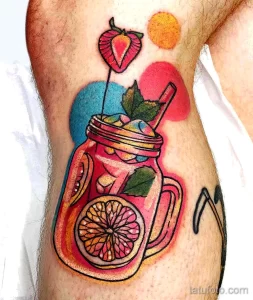 Фото татуировки яркого коктейля в стеклянной банке Mason Jar, украшенного дольками апельсина и листьями мяты. Стильный и современный рисунок.