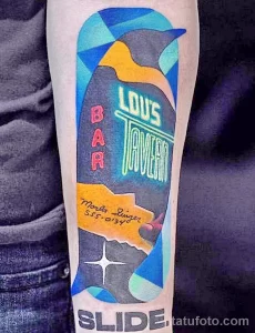 Фото тату пингвина в стиле поп-арт с надписями "Bar" и "Lou's Tavern". Яркие цвета, геометрические формы.