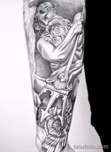 Фото тату с изображением богини и раковины на руке, выполненное в черно-белом стиле. Детализированное изображение фигуры и морских элементов.