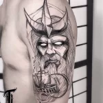 Фото тату викинга с кораблем на плече. Черно-белый рисунок в стиле графика с точечной техникой. Изображение сурового воина и парусника в бушующем море.