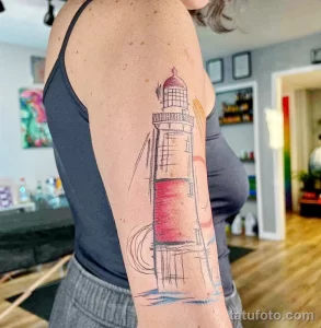 Фото тату: красочная татуировка маяка в стиле олд скул на предплечье, с волнами и линиями.