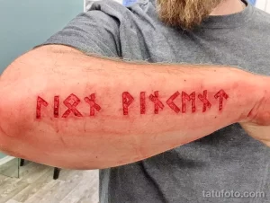 Фото тату: руническая надпись на предплечье, красные руны на коже, пример скандинавской татуировки, эскиз рунической татуировки.