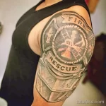 Фото тату пожарного на плече: реалистичный рисунок с надписью 'Fire Rescue', символизирующий мужество и самоотверженность.
