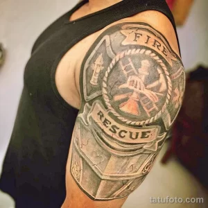 Фото тату пожарного на плече: реалистичный рисунок с надписью 'Fire Rescue', символизирующий мужество и самоотверженность.