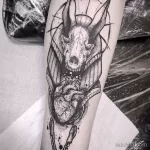 Фото тату Анубиса на ноге в стиле Blackwork. Изображение выполнено в черно-белых тонах с использованием плотных штрихов и геометрических фигур.
