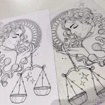 Черно-белый эскиз татуировки с изображением богини правосудия Весы, держащей весы в руках. Детализированный рисунок с элементами декора.