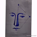 Простой эскиз тату, изображающий весы и контур лица. Минималистичный дизайн, выполненный синей ручкой на бумаге.