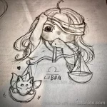 Фото эскиза тату Весы в мультяшном стиле. Изображение милой девушки с завязанными глазами, держащей весы, на фоне звезд и сердечек.