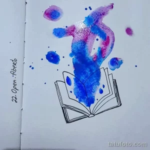 Красивое фото тату с изображением открытой книги, из которой вырывается поток акварельных красок. Нежный и мечтательный дизайн для творческих личностей.