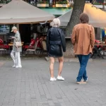 Фото тату на икре: японский стиль, изображение цветка сакуры и волн, выполненное в черных чернилах. Детализированный рисунок татуировки.