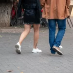 Фото тату на икре: японский стиль, изображение цветка сакуры и волн, выполненное в черных чернилах. Детализированный рисунок татуировки.
