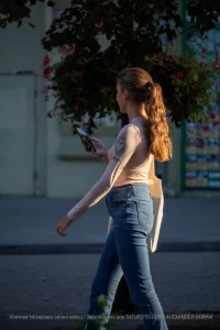 Фото тату на руке девушки: изображение сердца в стиле олд скул с надписью 'Amore'. Выполнено в черно-белой гамме, выглядит стильно и изящно.