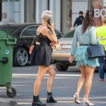 Фотография девушки с татуировкой на руке, говорящей по телефону. Детализированный рисунок, современный стиль и привлекательный дизайн. Идеально для поиска идей.