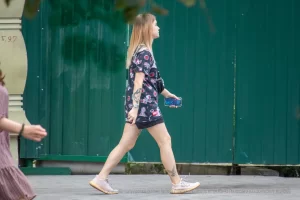 Фото тату на бедре с изображением черепов, украшенных яркими цветами в стиле олдскул. Рисунок выполнен в насыщенных красных, черных и зеленых тонах.