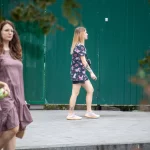 Фото тату на бедре с изображением черепов, украшенных яркими цветами в стиле олдскул. Рисунок выполнен в насыщенных красных, черных и зеленых тонах.