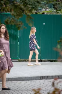 Фото тату на бедре с изображением черепов, украшенных яркими цветами в стиле олдскул. Рисунок выполнен в насыщенных красных, черных и зеленых тонах.