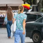Фото тату на предплечье с изображением множества лесных животных: зайцев, лис, ежей и птиц в мультяшном стиле. Рисунок выполнен в пастельных тонах.