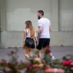 Фотография пары, идущей по улице: у мужчины и женщины видны татуировки на руках.