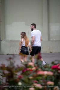 Фотография пары, идущей по улице: у мужчины и женщины видны татуировки на руках.