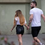 Фотография пары, идущей по улице: у мужчины и женщины видны татуировки на руках.