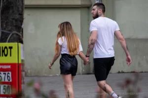 Фотография пары, идущей по улице: у мужчины и женщины видны татуировки на руках.