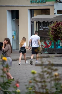 Фотография пары, идущей по улице: у мужчины и женщины видны татуировки на руках.