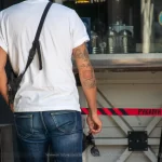 Крупный план татуировки на руке мужчины, выполненной в традиционном стиле. Видны детали рисунка, включая цветы и морские элементы.