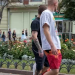 Фото мужчины с татуировками на руке и ноге, идущего по улице. Идеи для тату, эскиз тату, мастер тату.
