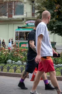 Фото мужчины с татуировками на руке и ноге, одетого в яркие шорты. Идеи для тату, эскиз тату, мастер тату.
