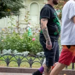 Фото мужчины с татуировками на руке и ноге, а также с изображением листа марихуаны на футболке. Идеи для тату, эскиз тату, мастер тату.