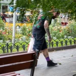 Фото татуировки на спине мужчины: листья марихуаны, черепа и другие элементы. Уличная фотография.